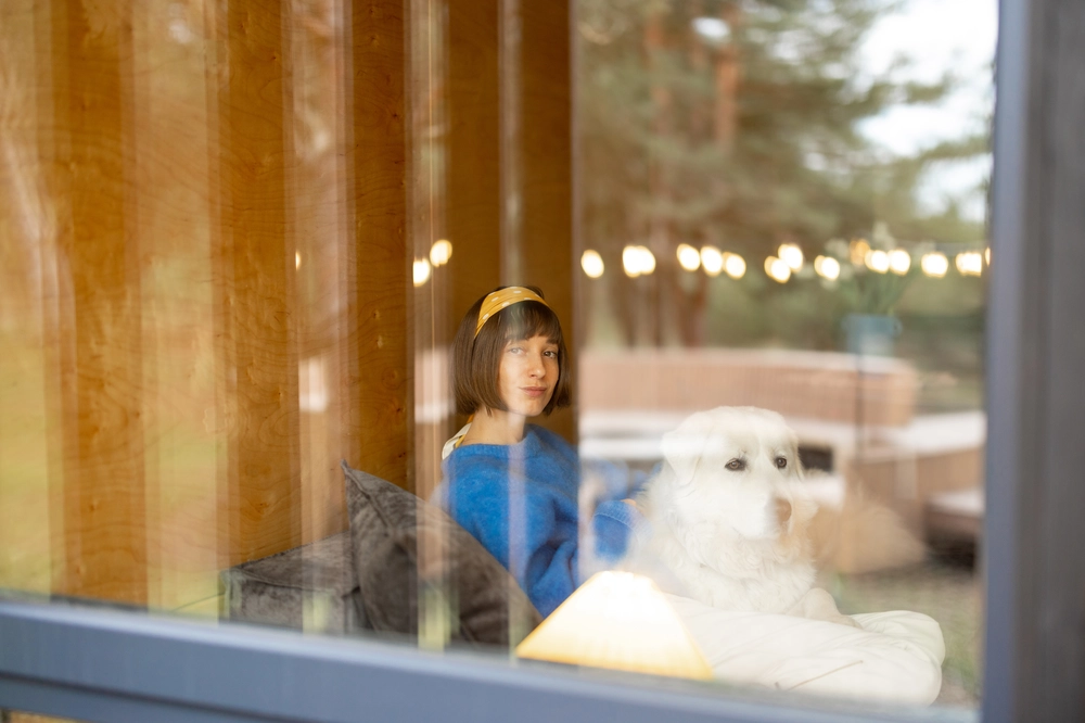 woman-with-dog-in-house-view-through-the-window